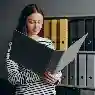 Records manager organizing digital and paper files for better business control through records and management systems